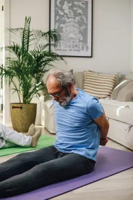 Homme pratiquant le yoga à domicile