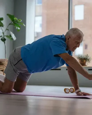 homme senior en posture de yoga à son domicile